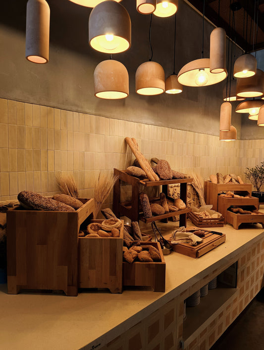 Warm artisan bakery display with rustic loaves and bread under pendant lights